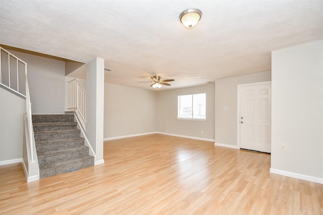 interior space with ceiling fan, a textured ceiling, and light hardwood / wood-style flooring