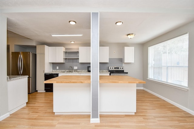 kitchen with stainless steel appliances, sink, white cabinets, and wooden counters