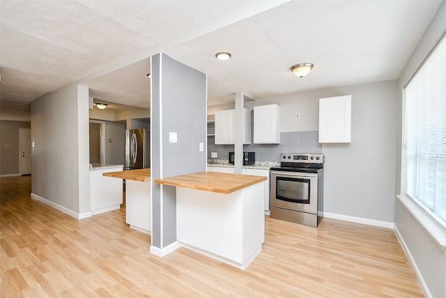 kitchen with a center island, butcher block counters, light wood-type flooring, white cabinetry, and stainless steel appliances