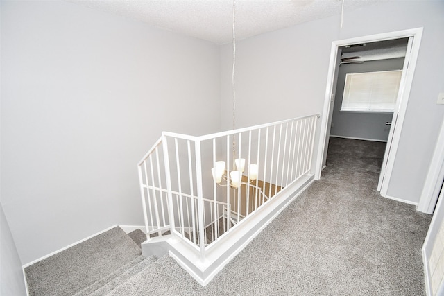 hallway featuring carpet floors and a textured ceiling