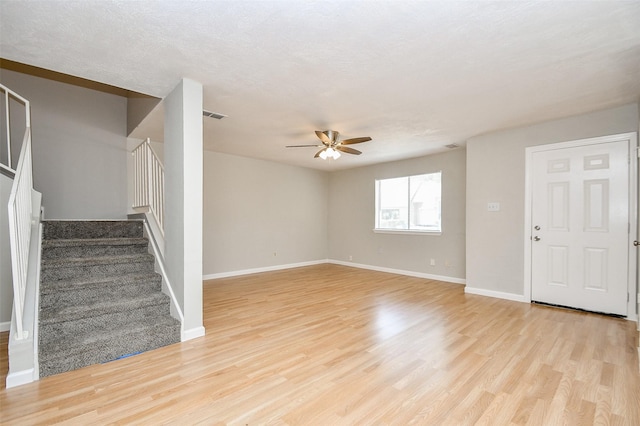 unfurnished living room with ceiling fan, light hardwood / wood-style flooring, and a textured ceiling