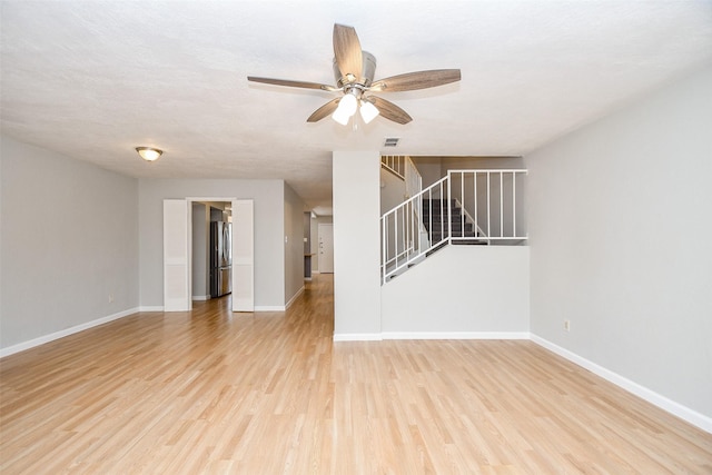 unfurnished living room with ceiling fan and light hardwood / wood-style flooring