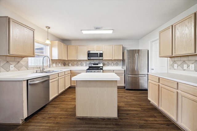 kitchen featuring stainless steel appliances, sink, pendant lighting, light brown cabinets, and a kitchen island