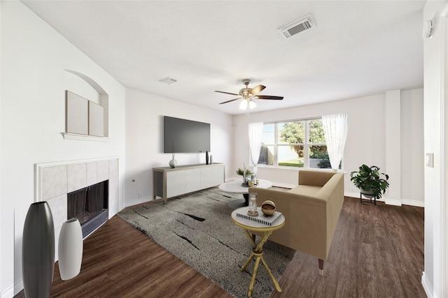 living room with a fireplace, dark hardwood / wood-style flooring, and ceiling fan