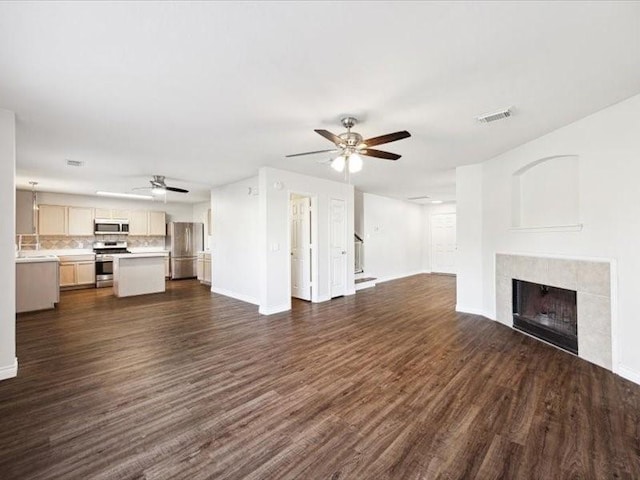 unfurnished living room featuring ceiling fan and dark wood-type flooring