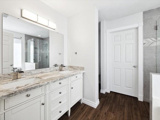 bathroom featuring hardwood / wood-style flooring, vanity, and walk in shower