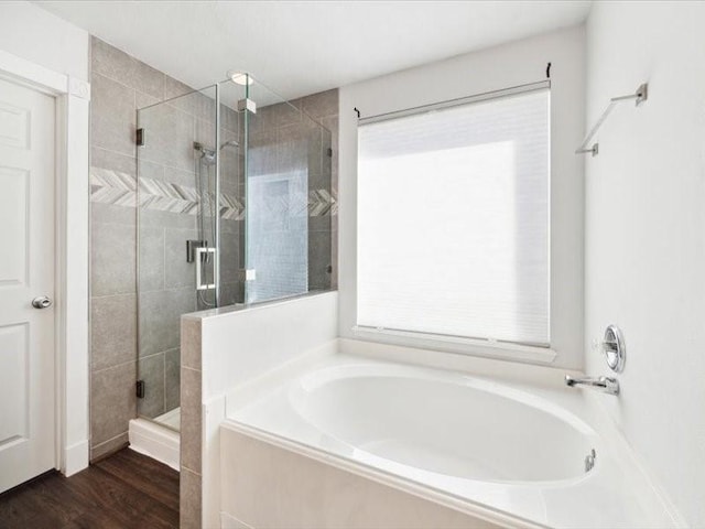 bathroom with hardwood / wood-style floors and shower with separate bathtub