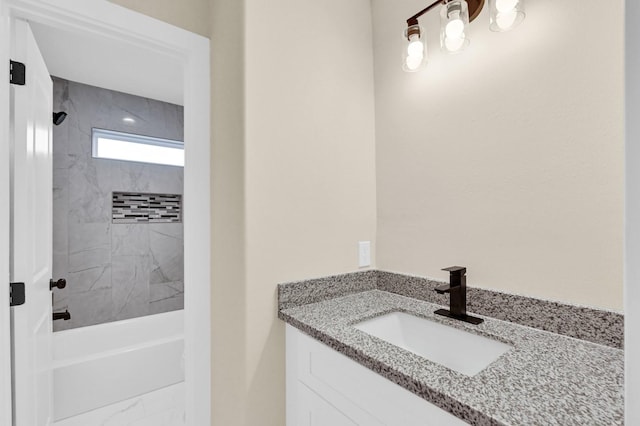 bathroom with vanity and tiled shower / bath