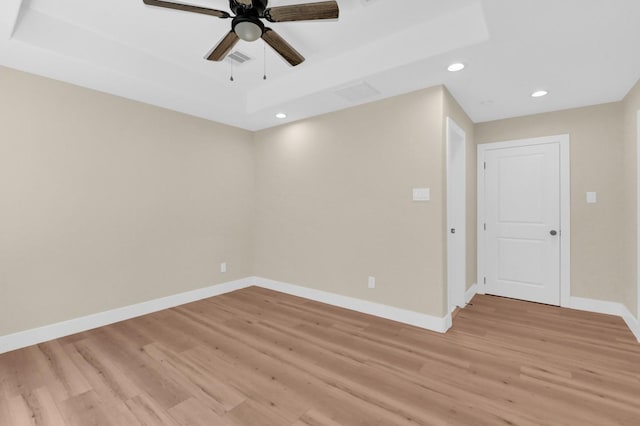 empty room with ceiling fan and light hardwood / wood-style floors