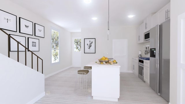 kitchen with a breakfast bar, white cabinets, stainless steel fridge, an island with sink, and decorative light fixtures