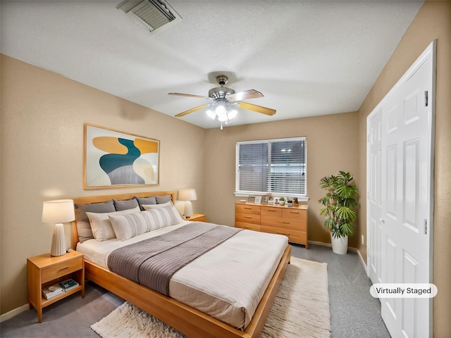 carpeted bedroom featuring ceiling fan and a closet