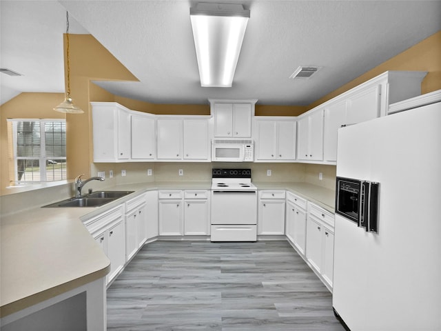 kitchen with white appliances, white cabinetry, hanging light fixtures, and sink