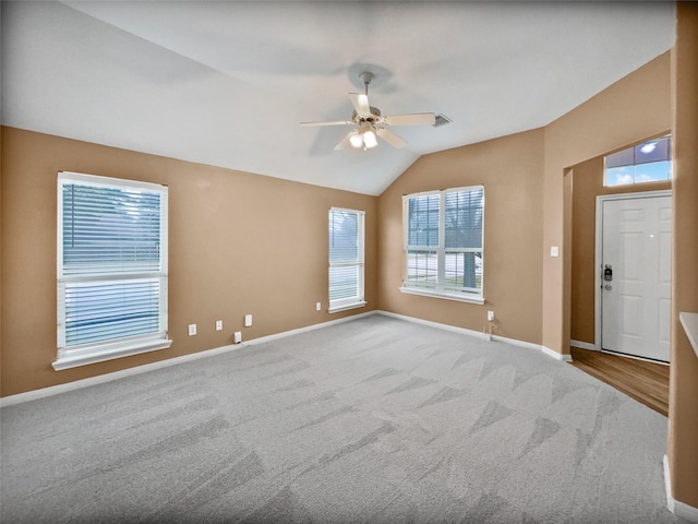 carpeted spare room with ceiling fan and lofted ceiling