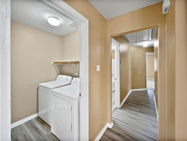 washroom with light hardwood / wood-style floors and separate washer and dryer