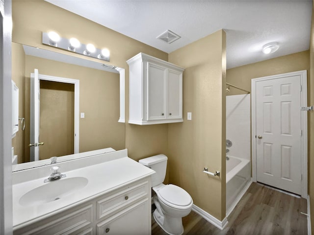 full bathroom featuring vanity,  shower combination, hardwood / wood-style flooring, toilet, and a textured ceiling