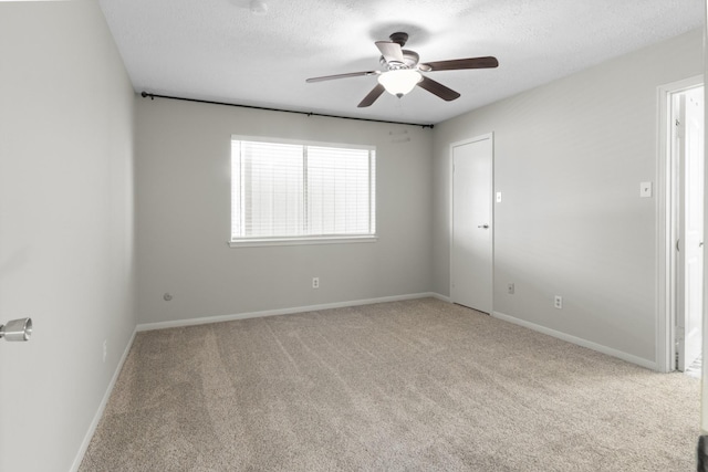 unfurnished room with a textured ceiling, ceiling fan, and light carpet