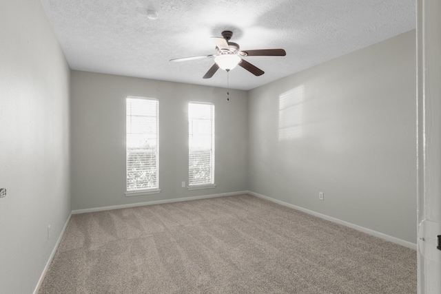 spare room featuring light carpet, a textured ceiling, and ceiling fan