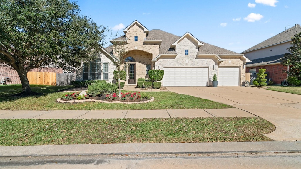 view of front of home with a garage and a front lawn