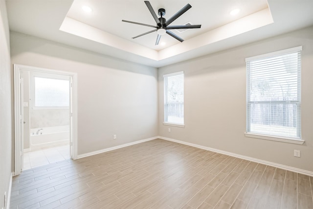 spare room featuring ceiling fan and a raised ceiling