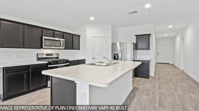 kitchen featuring light hardwood / wood-style floors, sink, a kitchen island with sink, and appliances with stainless steel finishes