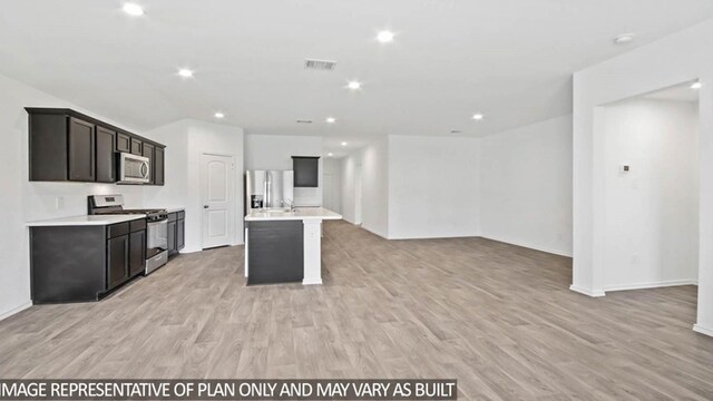 kitchen with appliances with stainless steel finishes, a center island with sink, and light hardwood / wood-style flooring