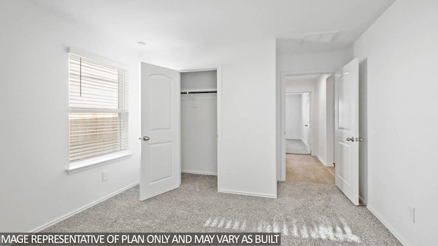 unfurnished bedroom with light carpet and a closet