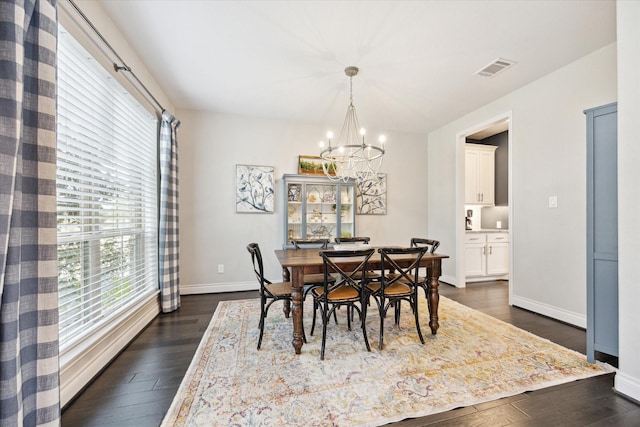 dining area featuring dark hardwood / wood-style floors, a wealth of natural light, and a chandelier