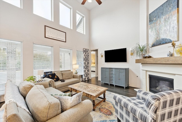 living room featuring a high ceiling, dark hardwood / wood-style floors, and plenty of natural light