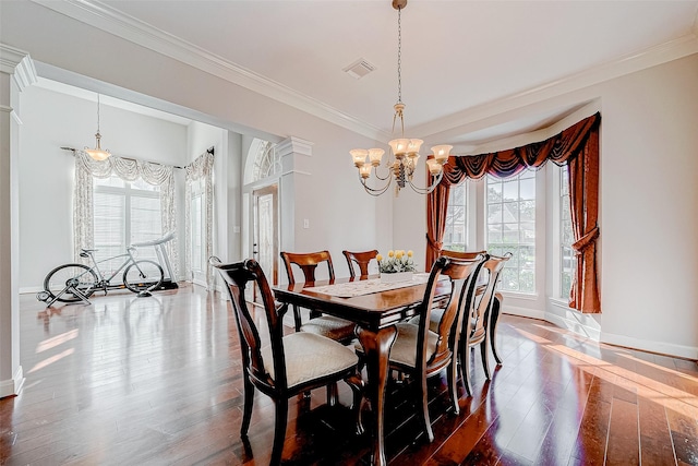 dining space with an inviting chandelier, crown molding, and dark wood-type flooring