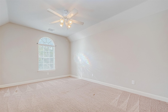 spare room featuring ceiling fan, vaulted ceiling, and light carpet