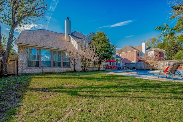 rear view of property with a lawn and a patio area