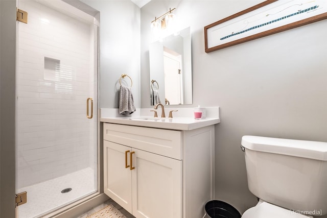 bathroom featuring vanity, toilet, and an enclosed shower