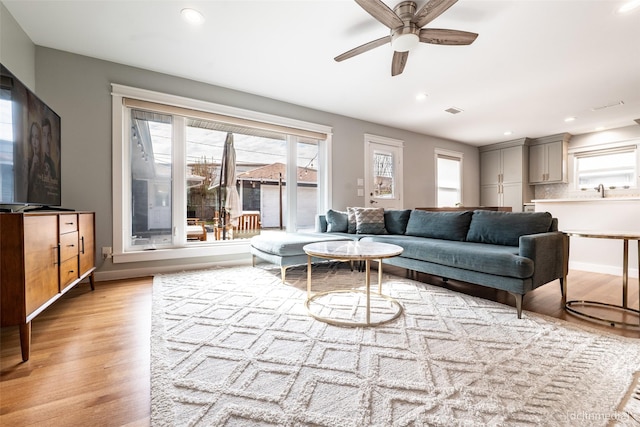 living room with ceiling fan and light hardwood / wood-style floors