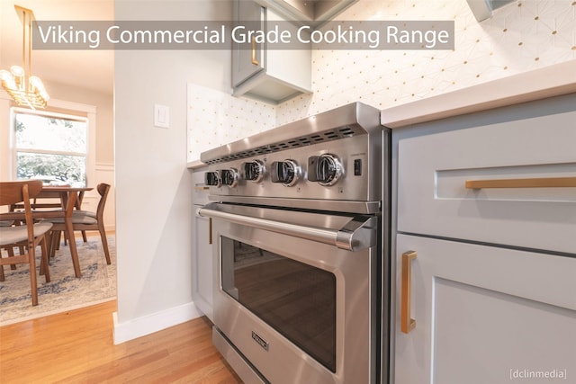 kitchen with a chandelier, light hardwood / wood-style floors, and stainless steel stove