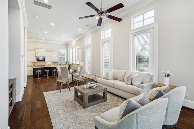 living room featuring dark hardwood / wood-style flooring, ceiling fan, and ornamental molding