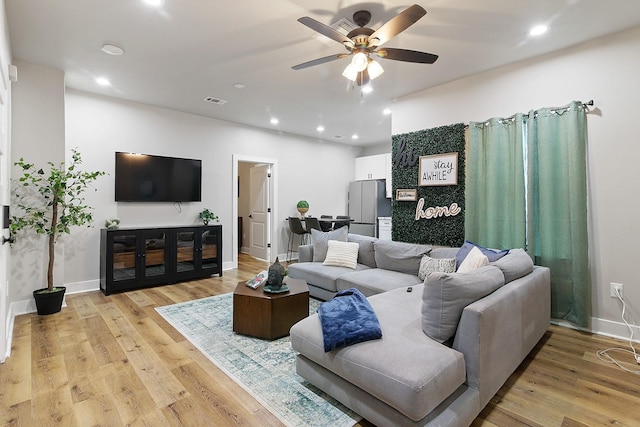 living room with ceiling fan and light wood-type flooring