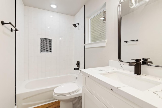 full bathroom featuring wood-type flooring, vanity, toilet, and tiled shower / bath combo