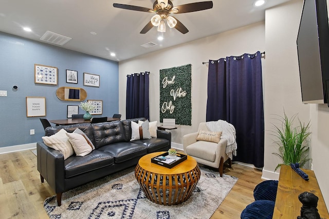 living room featuring light hardwood / wood-style flooring and ceiling fan