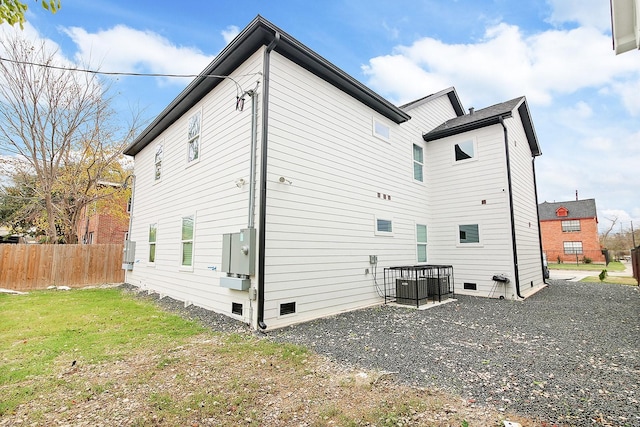 back of property with a lawn and central air condition unit