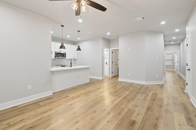 unfurnished living room featuring ceiling fan and light hardwood / wood-style flooring