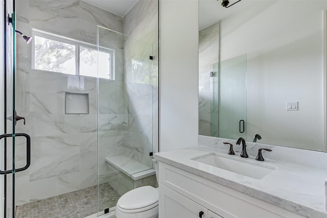 bathroom with toilet, vanity, and walk in shower