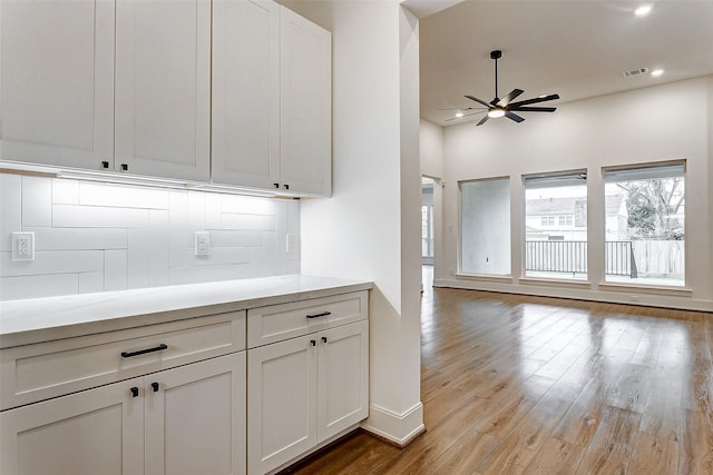 kitchen featuring tasteful backsplash, ceiling fan, light hardwood / wood-style flooring, and white cabinets