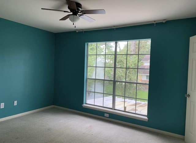 unfurnished room with ceiling fan, carpet floors, and a wealth of natural light