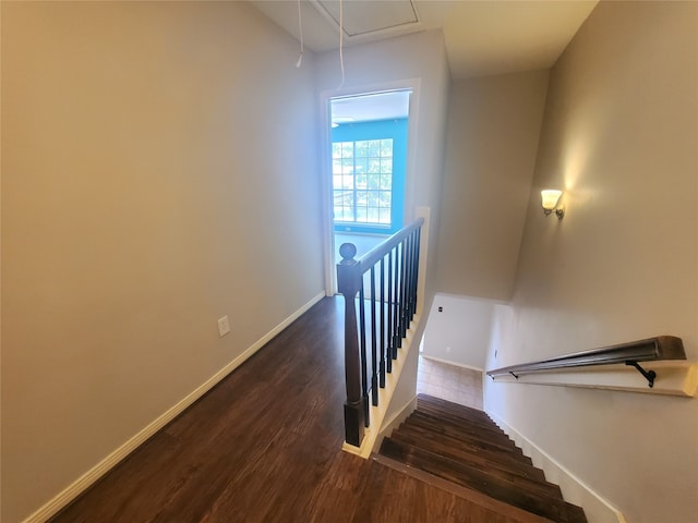 staircase featuring baseboards, attic access, and wood finished floors
