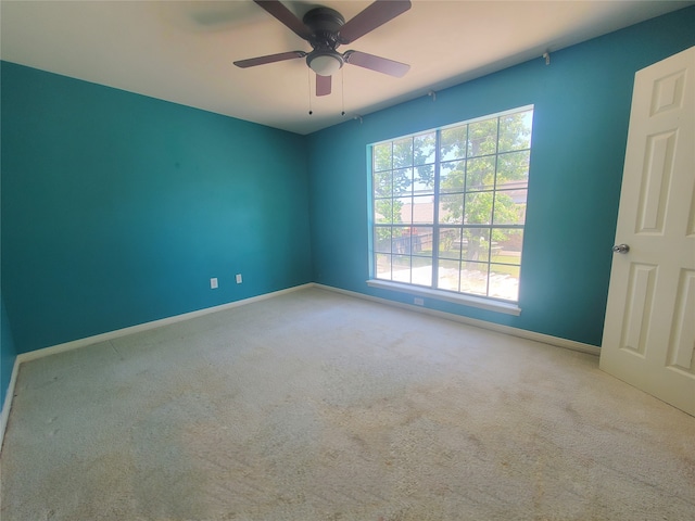unfurnished room featuring baseboards, a ceiling fan, and carpet
