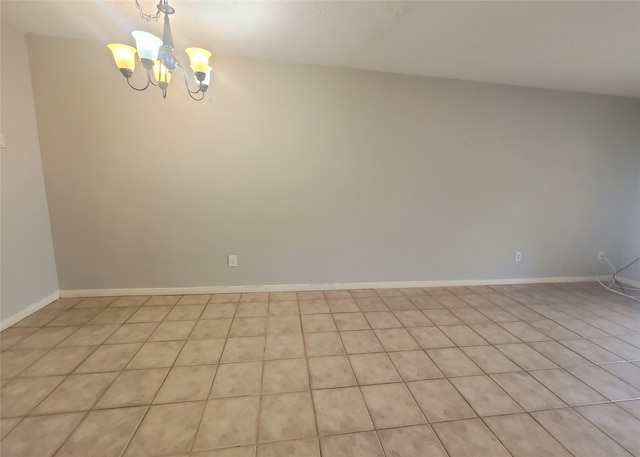 spare room with baseboards and an inviting chandelier