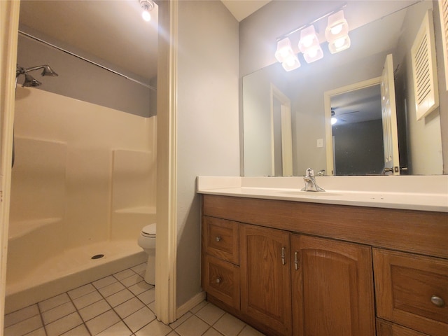full bathroom featuring toilet, tile patterned floors, vanity, and walk in shower