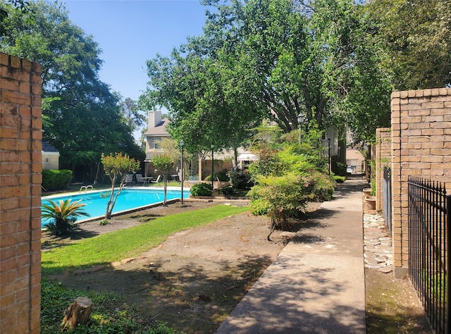 view of pool with a fenced in pool and fence
