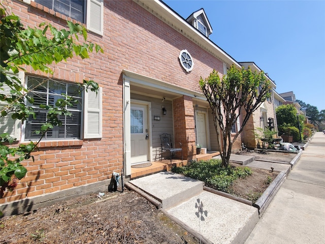 doorway to property featuring brick siding