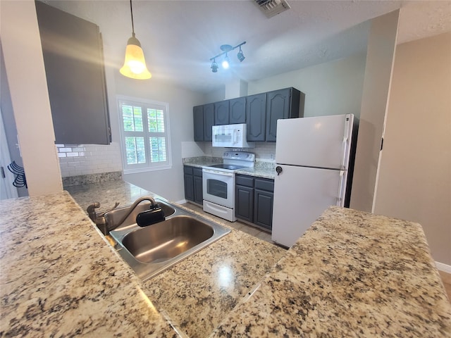 2030 Plantation Dr Unit B-2, Conroe, TX 77301 - kitchen with white appliances, a sink, decorative backsplash, light countertops, and hanging light fixtures